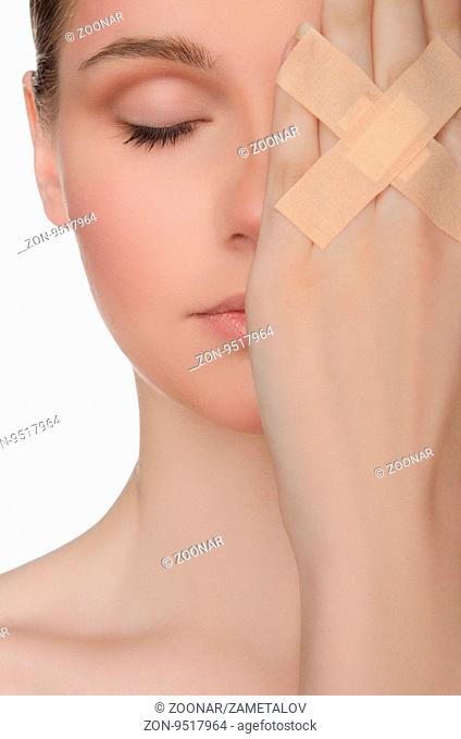face of beautiful woman with plaster on his hand