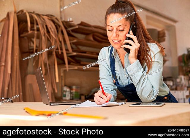 Handwerker Frau bei Kundenberatung am Telefon in der Schreinerei Werkstatt