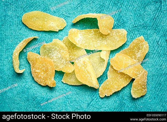 crystallized ginger slices against tuquoise bark paper