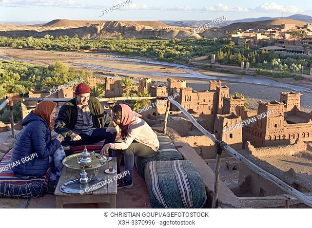 people sitting on the terrace of a cafe overlooking the Ksar of Ait-Ben-Haddou, Ounila River valley, Ouarzazate Province, region of Draa-Tafilalet, Morocco