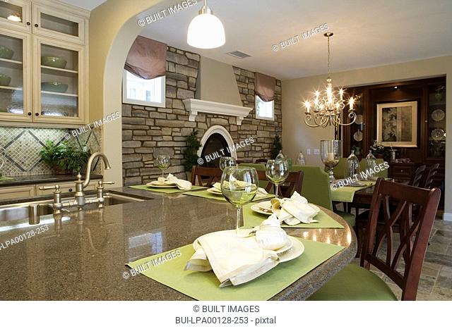 Kitchen with breakfast bar and dining room with stone wall