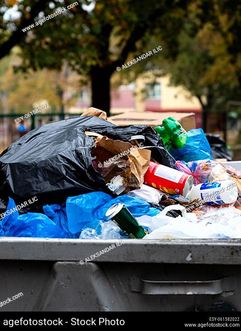 Belgrade, Serbia - November 02, 2022: Dumpster full of trash. Garbage falling all over. Stop pollution, start Recycling and save our Planet