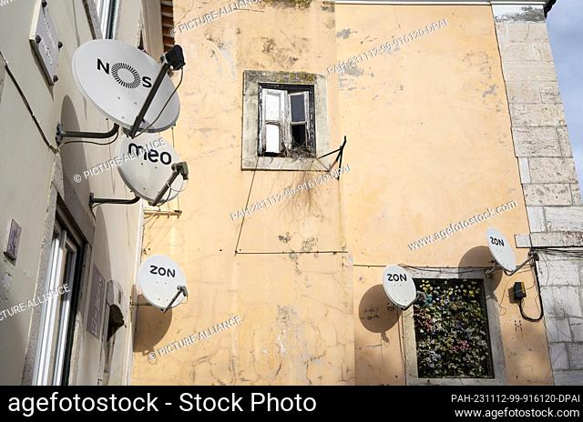 PRODUCTION - 27 October 2023, Portugal, Lissabon: Satellite dishes with the inscriptions of the companies ""Nos"" (l-r), ""Meo"" and ""Zon"" are attached to a...