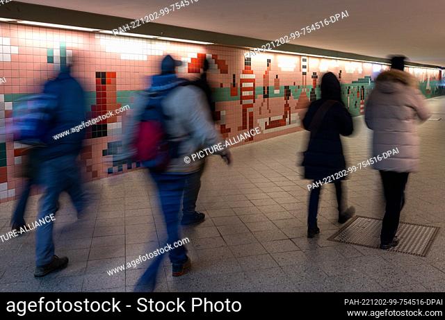 02 December 2022, Berlin: Passers-by walk through the pedestrian tunnel at Wannsee station designed by illustrator Christoph Niemann in 2018