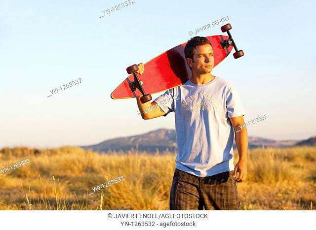 Young Male posing with his skate board