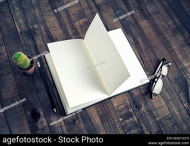 Blank booklet, stationery on vintage wood table background. Book, glasses, pencil and cactus. Responsive design mockup