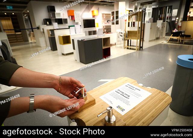 Illustration picture shows a person demonstrating the use of a bottle of disinfecting liquid at the Anderlecht branch of the Ikea furniture stores