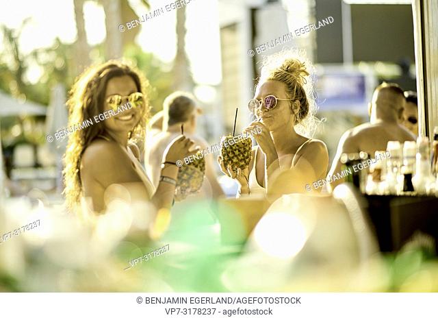 Two women drinking cocktails at bar, Hersonissos, Crete, Greece