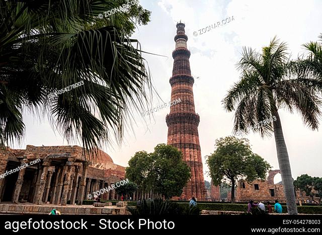 qutub minar in new delhi surrounded by various ruins viewed from below. New Delhi, India