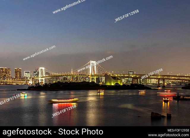 Japan, Kanto Region, Tokyo, Long exposure of Tokyo Bay at dusk with Rainbow Bridge in background