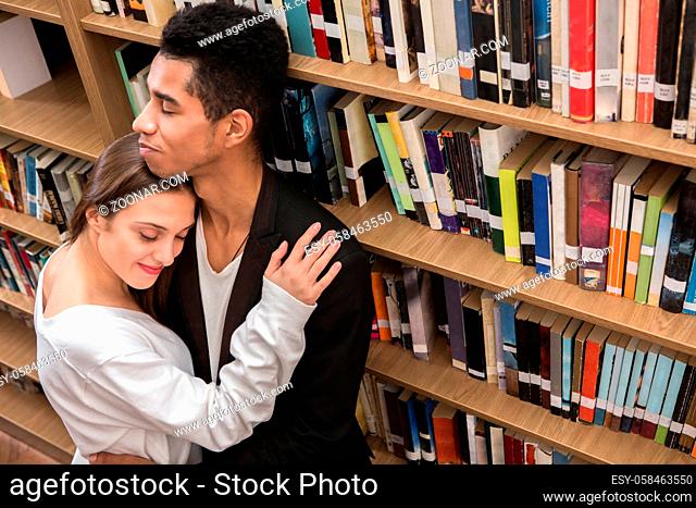 Beautiful couple in love get acquainted in library. Young couple of students resting and relaxing in library
