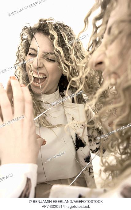 wild screaming woman with broken mirror, in Paris, France