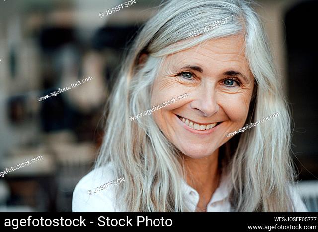 Smiling mature woman with gray hair at cafe