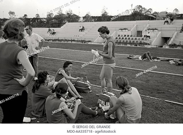 Giuseppina Leone relaxing. Italian athlete Giuseppina Leone relaxing on the trackside with her team mates. Rome, 1960