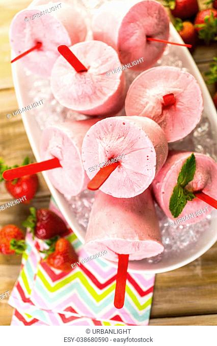 Homemade strawberry popsicles made in plastic cups