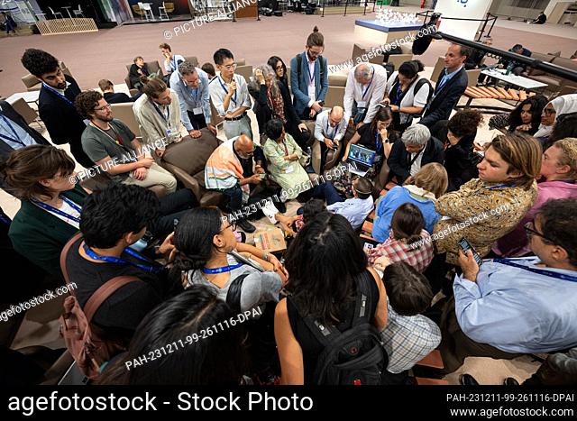 11 December 2023, United Arab Emirates, Dubai: People watch the speech by John Kerry, the US President's Special Envoy for Climate Change, on a laptop
