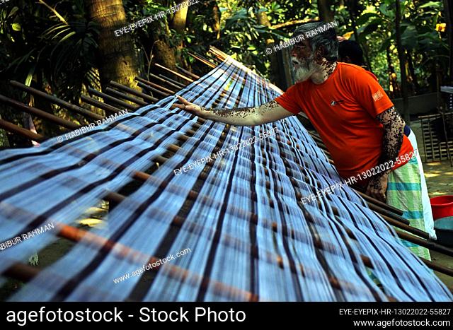 DHAKA, BANGLADESH - FEBRUARY 13, 2022: A employee work in the manufacture process of yarn to fabric production in a backyard at Keraniganj