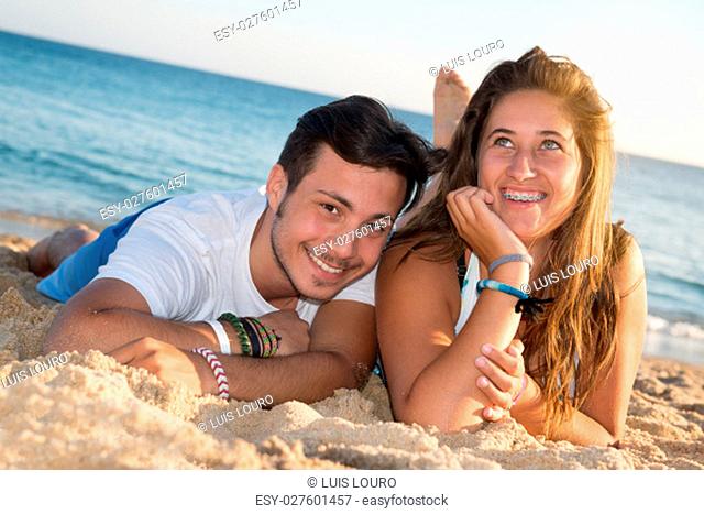 Happy teenage couple posing in the beach