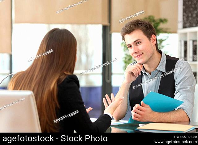 Satisfied businesspeople talking during an interview sitting at office