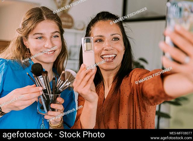 Women vlogging while showing beauty product and brushes