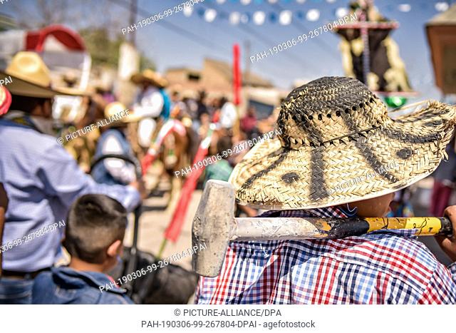 05 March 2019, Mexico, San Juan de la Vega: A participant of the ""Festival of Explosive Hammers"" waits with his hammer on his shoulder