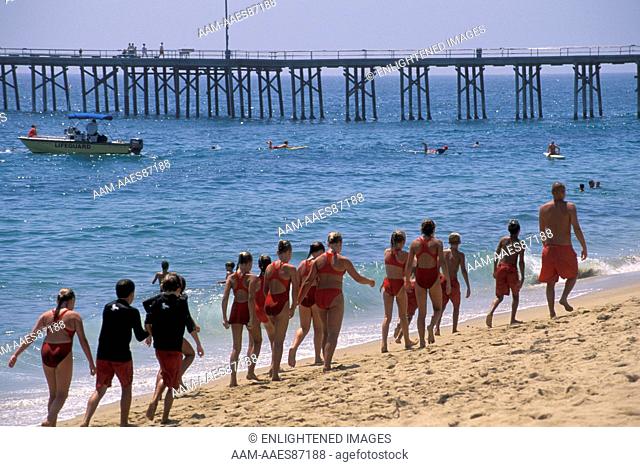 Kids walking on sand beach in summer class Junior Lifeguard Camp, Balboa Island, Newport Beach, California