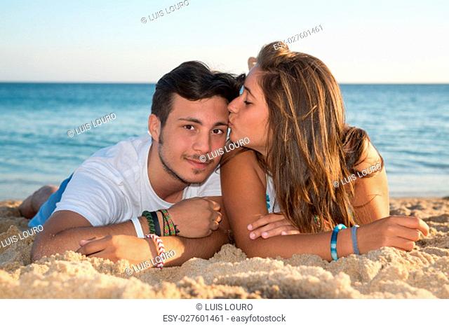 Happy teenage couple posing in the beach