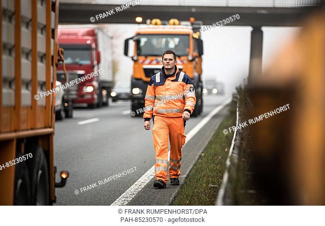 Road maintenance worker Brian Zutz walks to a vehicle on the closed passing lane on highway A485 near Giessen, Germany, 17 October 2016