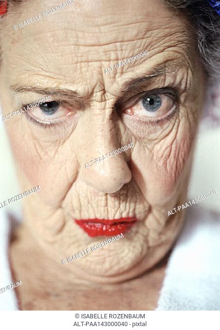 Elderly woman raising eyebrow and looking at camera, portrait, close-up