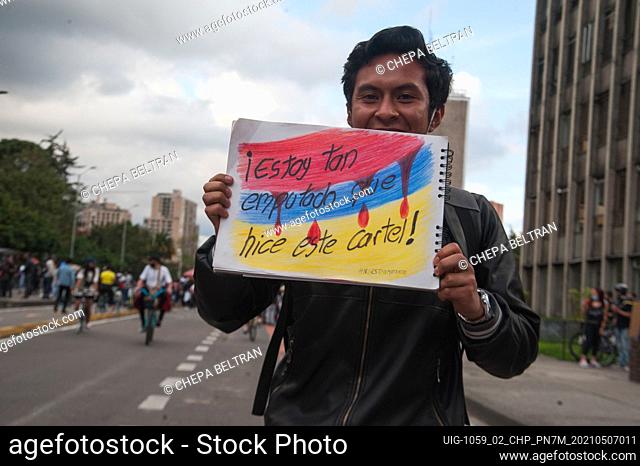 A demonstrator holds a sign that reads ""I am so raged out I made this sign"" with the Colombian flag in Bogota, Colombia on May 7 2021 after peaceful...