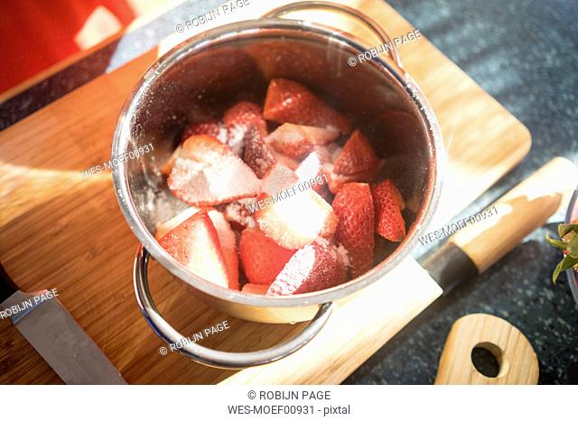 Making strawberry jam in cooking pot