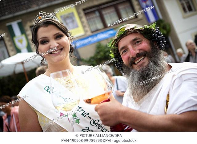 08 September 2019, Saxony-Anhalt, Freyburg: Annemarie Triebe, 50th wine queen of the Saale-Unstrut wine-growing region, and Bacchus, the god of wine