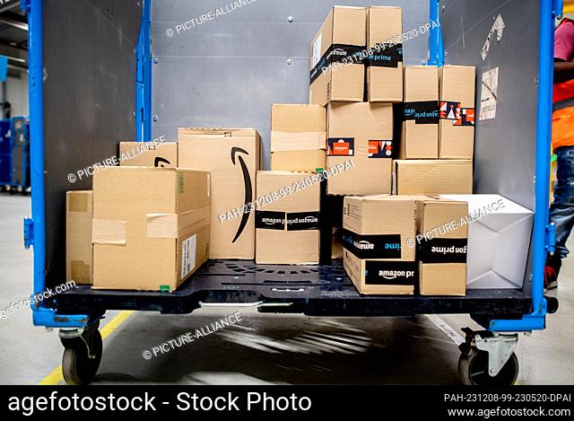 07 December 2023, Lower Saxony, Großenkneten: Numerous parcels are ready for dispatch on a trolley in the outgoing goods area of Amazon's new logistics center...