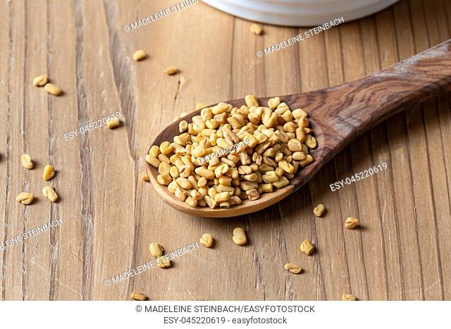 Fenugreek seeds on a wooden spoon