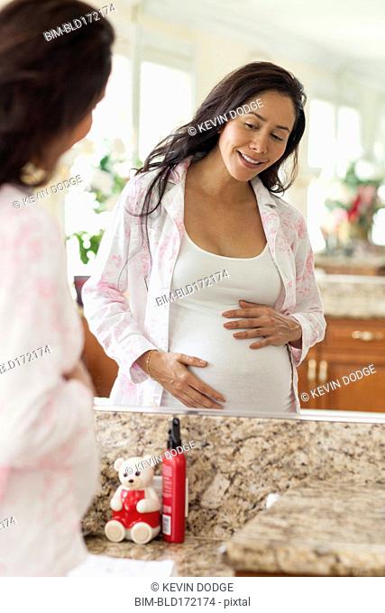 Pregnant Hispanic woman holding her belly