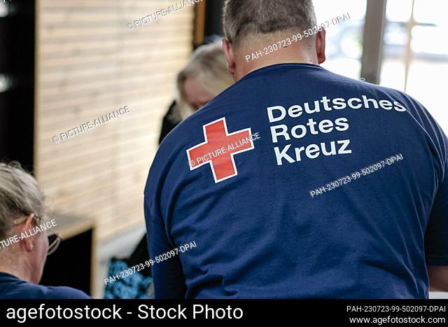 23 July 2023, Schleswig-Holstein, Kiel: People check in with German Red Cross staff at a collective shelter in the Hans Christian Andersen School