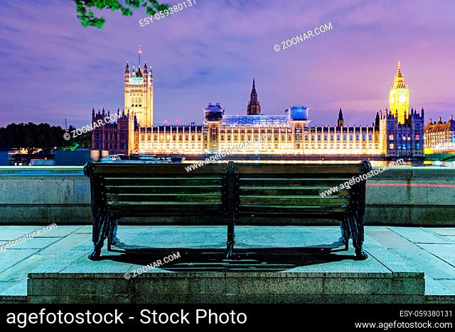 Bench at night with Houses of Parliament in the distance