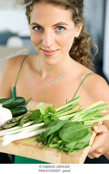 Woman holding vegetables in the kitchen