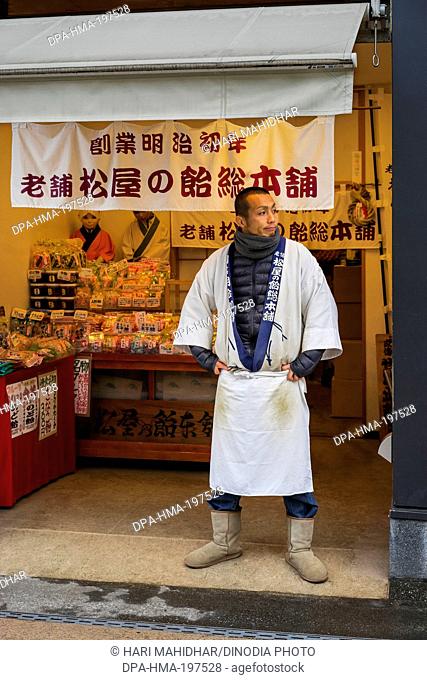 Japanese chief waiting outside bakery shop, kamakura streets, japan