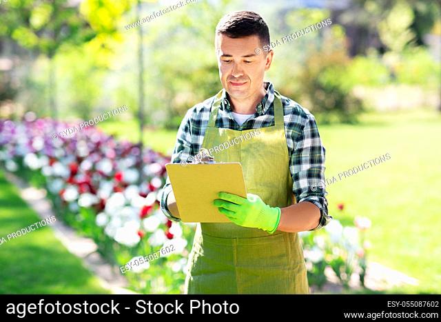 happy man with clipboard at summer garden