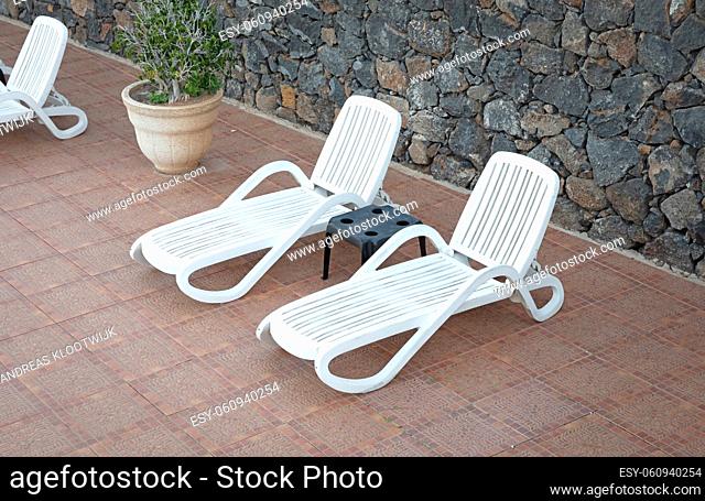 White chairs in garden near swimming pool, Lanzarote