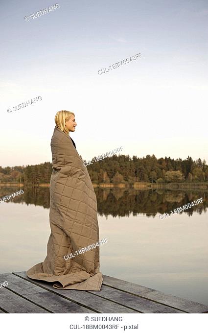 Young woman standing on jetty, enjoying