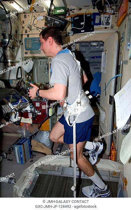 Russian cosmonaut Sergei Volkov, Expedition 29 flight engineer, equipped with a bungee harness, exercises on the Treadmill Vibration Isolation System (TVIS) in...