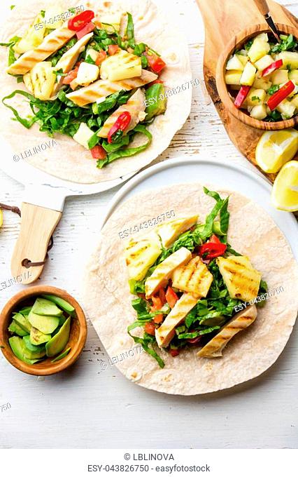 Mexican chicken tacos with grilled pineapple on wooden white background