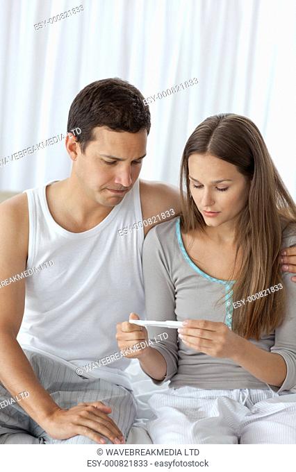 Young couple waiting for the result of the pregnancy test in the bedroom