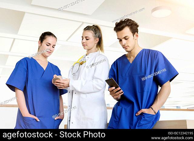 Germany, Bavaria, Munich, Young medical staff standing in corridor