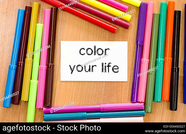 Felt-tip pen and note on a wooden background and color your life text concept