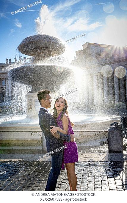 Couple getting wet next to a water fountain in Saint Peter's square. Vatican, Rome, Italy