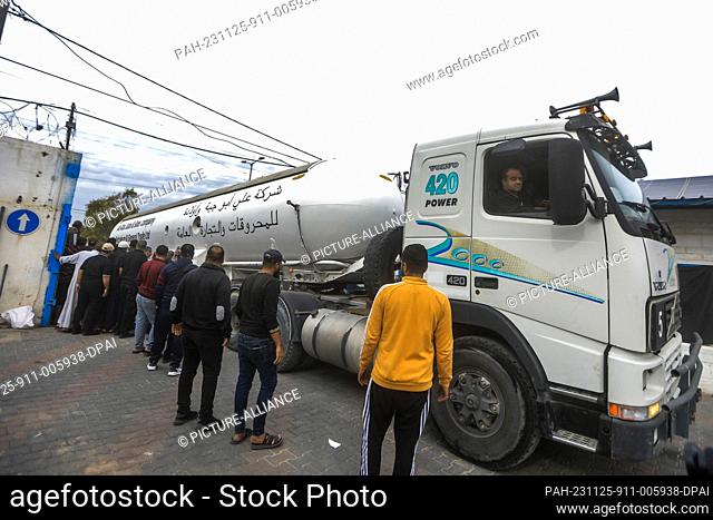 25 November 2023, Palestinian Territories, Khan Yunis: Palestinians look at a truck carrying liquid gas while entering Khan Yunis