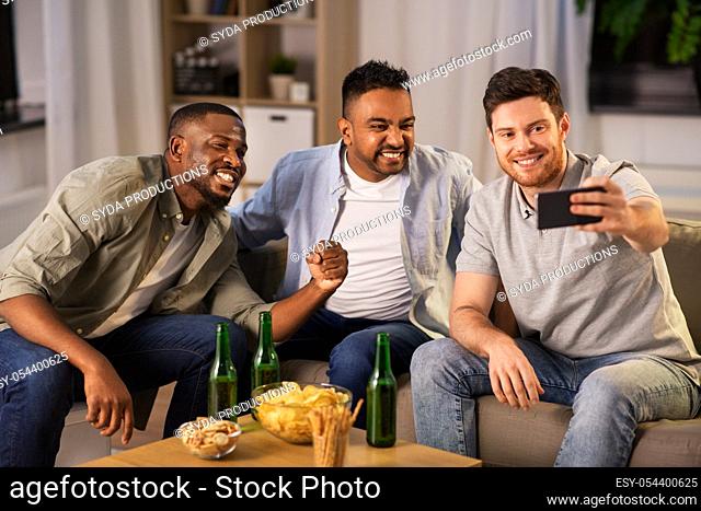 male friends with smartphone taking selfie at home